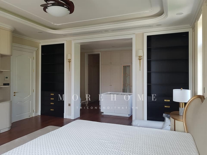 Sắp đặt một kệ tủ gỗ tự nhiên màu đen âm tường để trưng bày những món đồ có không gian gọn gàng khoa học sau khi thi công.
